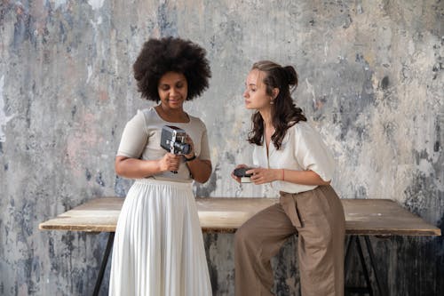 Two Women Holding Vintage Cameras