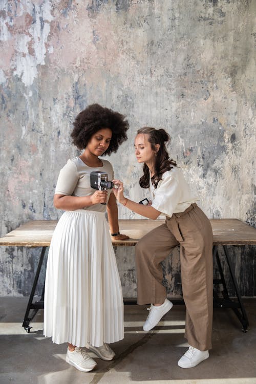 Two Women Looking at a Vintage Camera