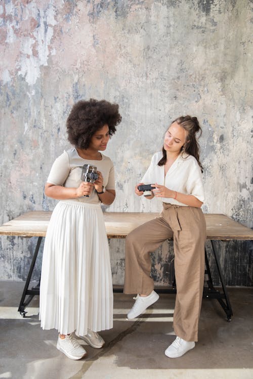 Two Women Holding Vintage Cameras