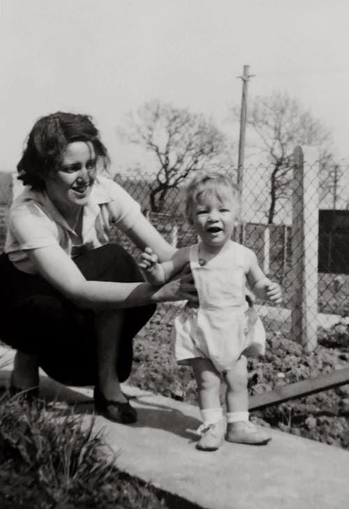 Grayscale Photo of a Woman Holding Her Baby