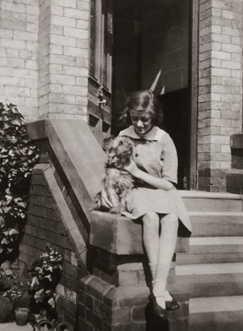 Girl Sitting By the Doorstep With a Dog