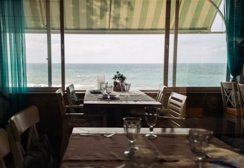 Free A cozy café in Sochi with a dining table overlooking the ocean, perfect for scenic dining. Stock Photo