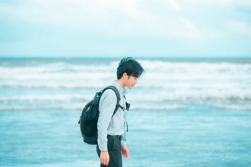 Man in Striped Dress Shirt Carrying a Backpack 