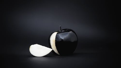 Black apple with slice cut out