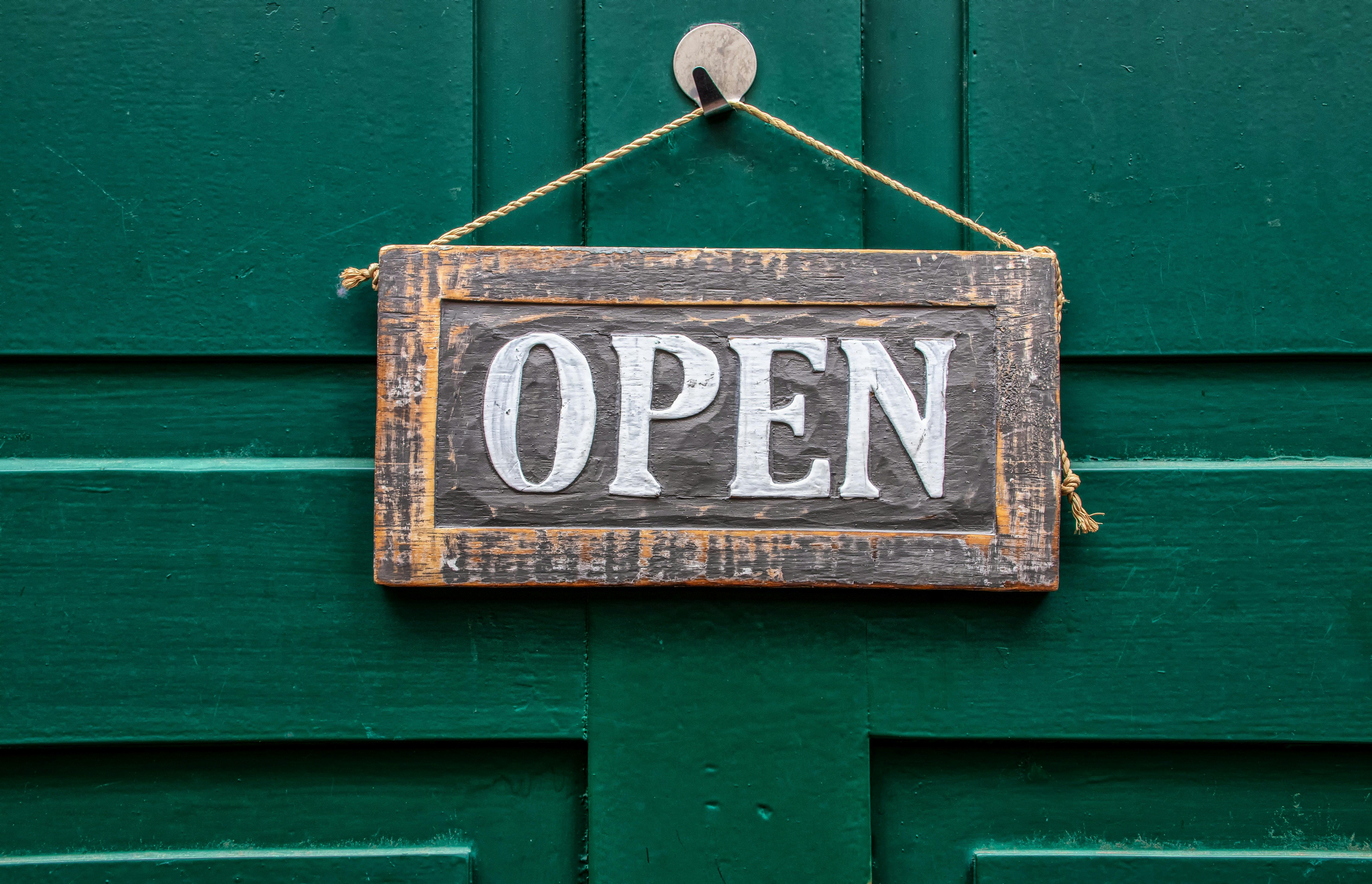 wooden welcome signage on green wooden door