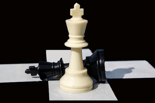 Close-Up View of White and Black Chess Pieces on a Chessboard