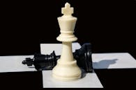 Close-Up View of White and Black Chess Pieces on a Chessboard