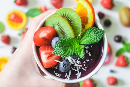 Colorful smoothie bowl topped with fresh fruits and mint for a healthy treat.