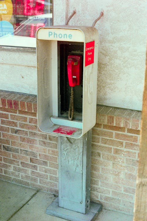 Free Red Public Telephone Mounted on a Wall Stock Photo