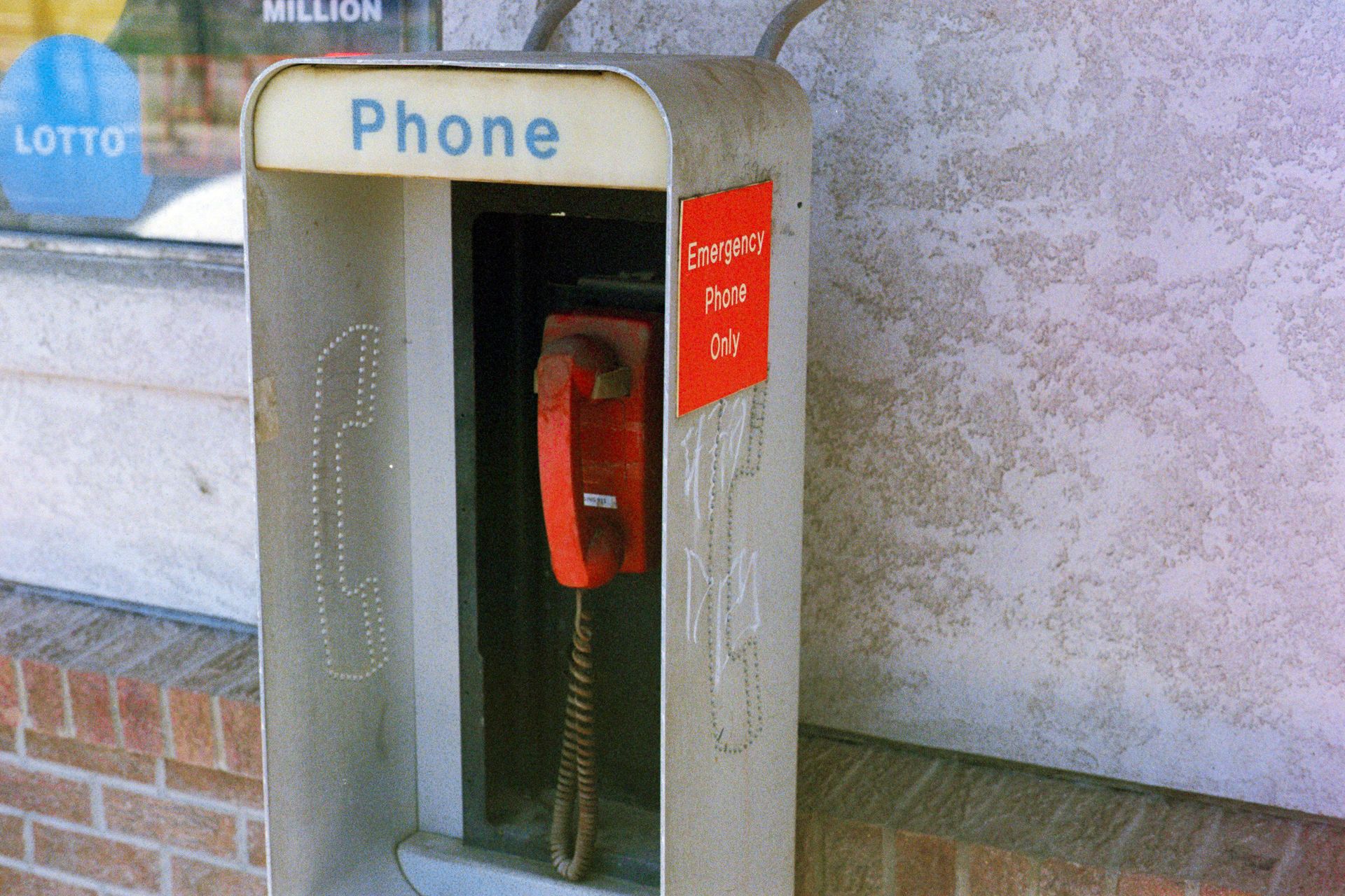 Retro emergency phone booth with red handset, symbol of outdated communication technology.