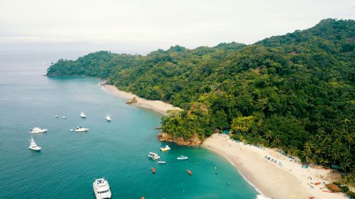Free Stunning aerial view of a tropical beach in Costa Rica with boats and lush greenery. Stock Photo