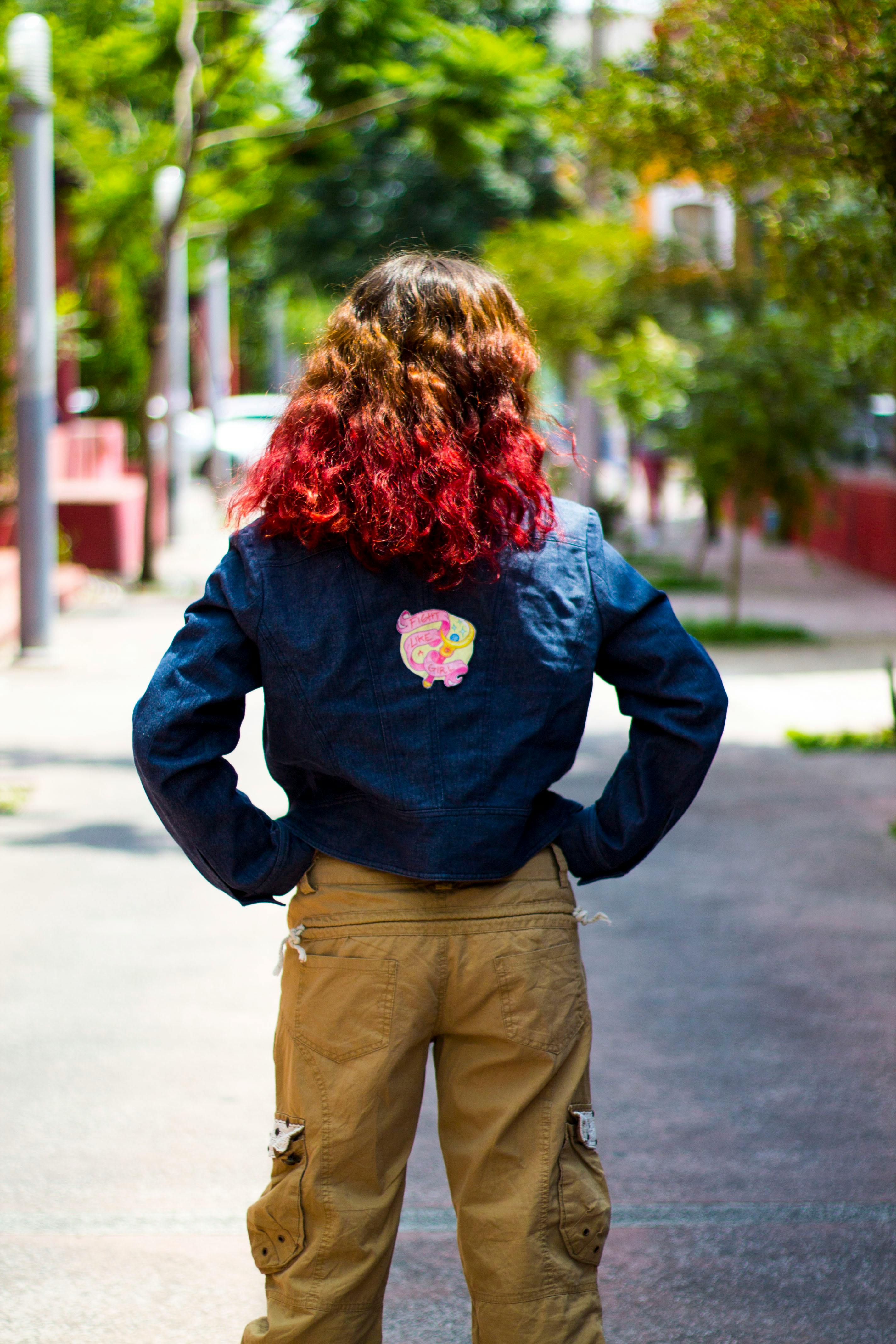 Woman in Blue Jacket and Brown Pants Standing on Gray Road · Free Stock