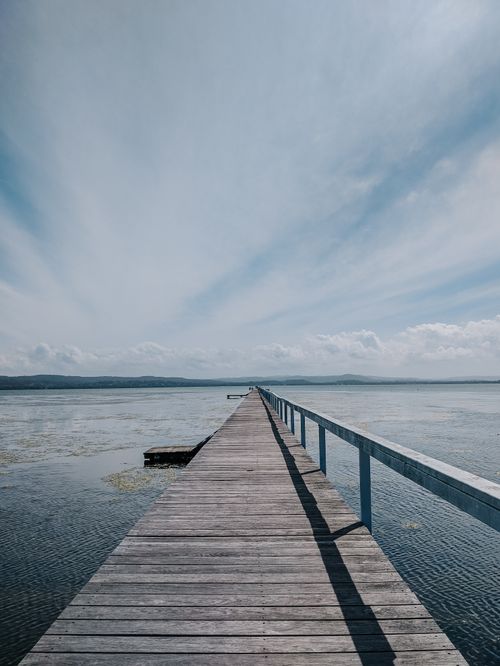 Free Long wooden jetty stretches into peaceful waters at Long Jetty, NSW, showcasing a serene horizon. Stock Photo