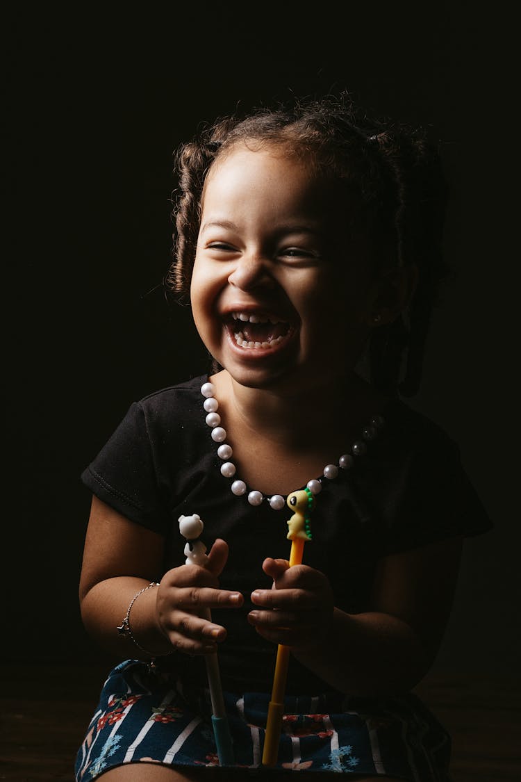 Happy Child Sitting And Laughing At Studio