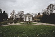 阴天下的斯特拉斯堡植物园里，草坪和树木郁郁葱葱，一座宁静的凉亭坐落其间