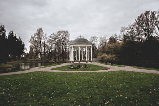 阴天下的斯特拉斯堡植物园里，草坪和树木郁郁葱葱，一座宁静的凉亭坐落其间