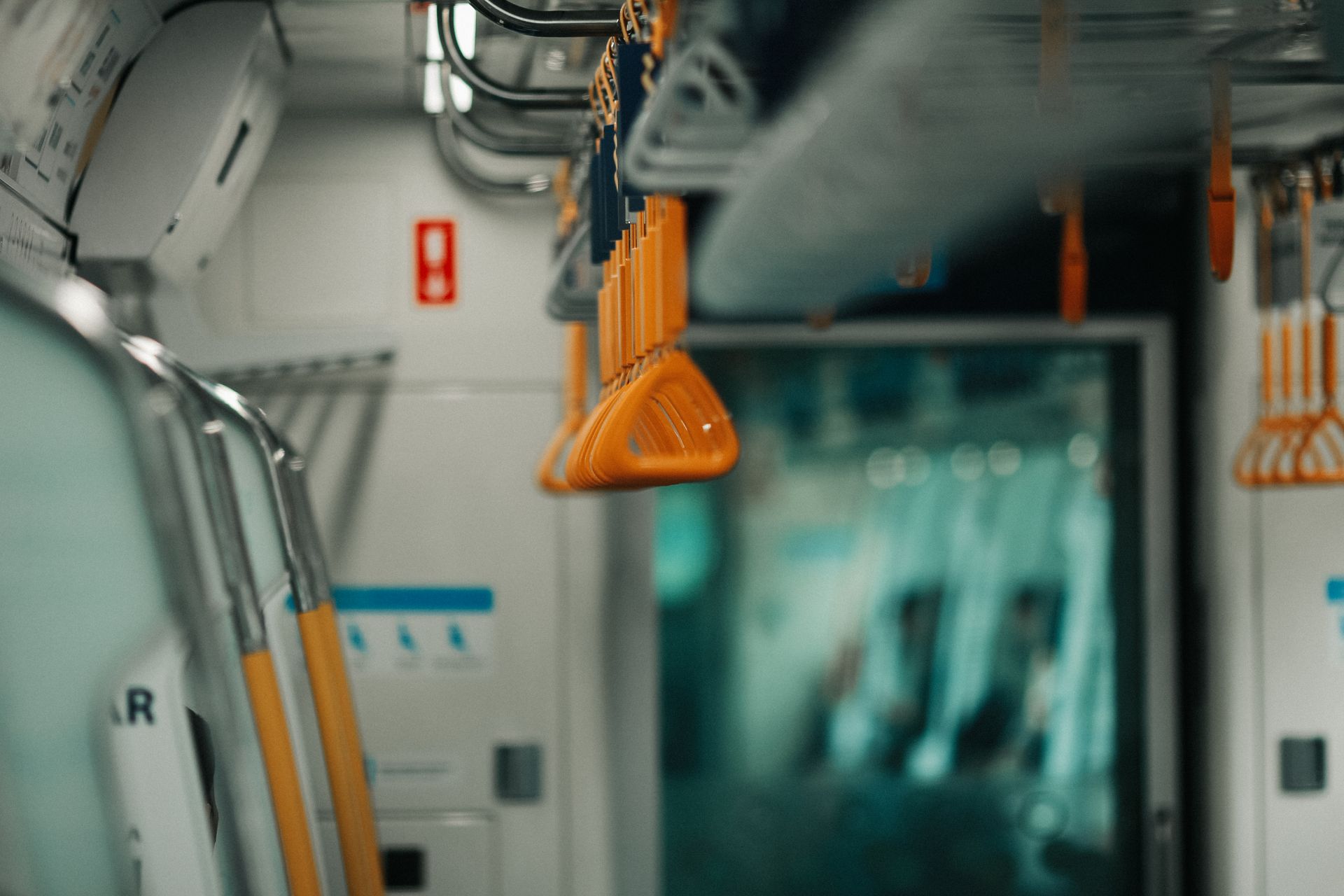 A sleek train interior showcasing orange handrails, offering a modern transportation vibe.