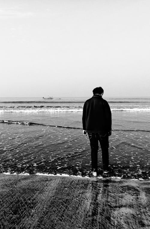 Back View of a Person Standing on Seashore