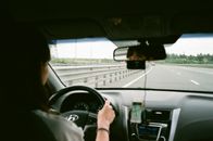 Woman driving car on road in daytime