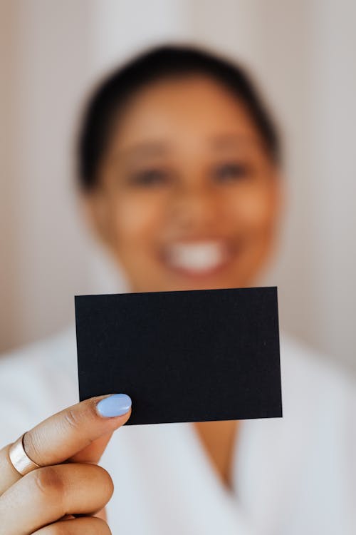 Person Holding a Small Black Paper