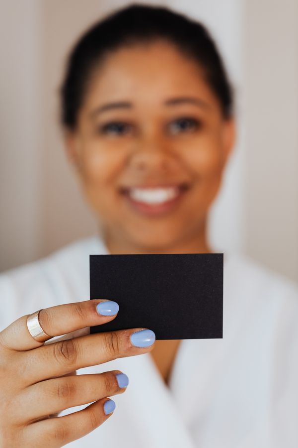 Person presenting a blank matte card — photo by Kaboompics on Pexels