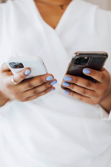 hand holding old smartphone next to new phone