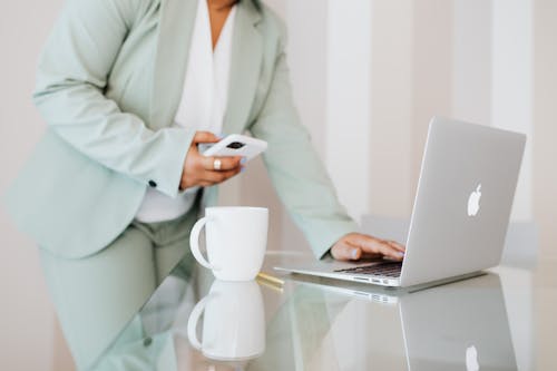 Free Person in Light Green Suit Using a Laptop Stock Photo