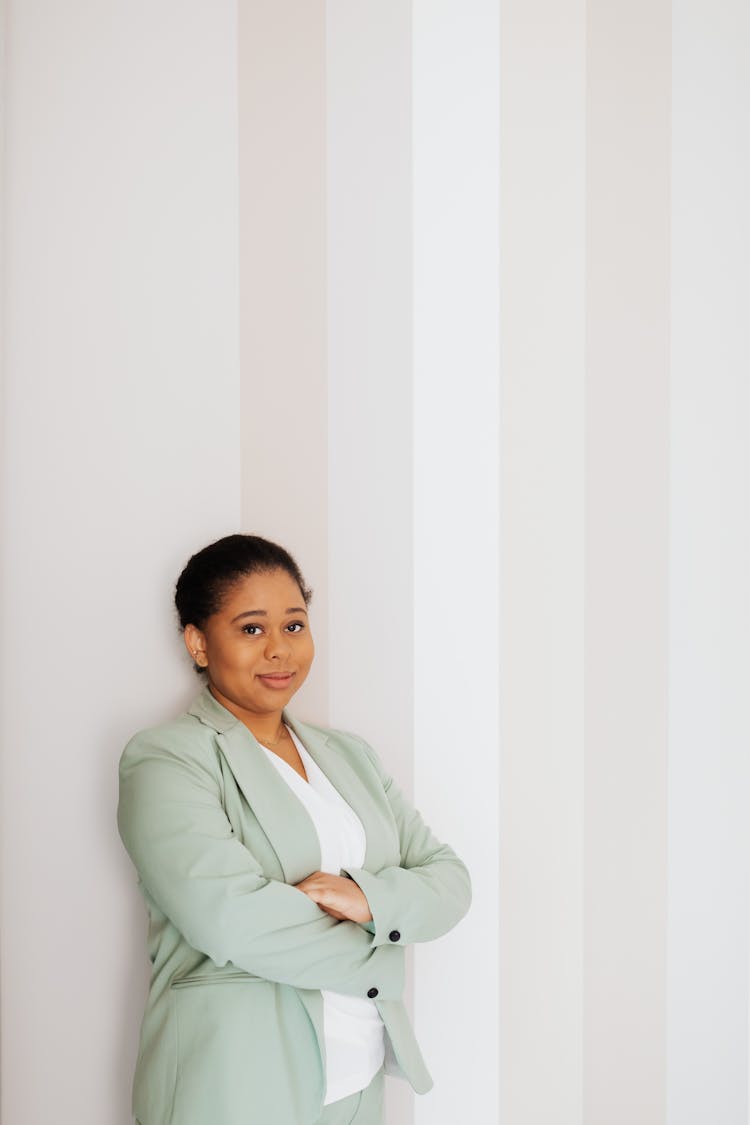 Woman In Light Green Suit Leaning On A Wall