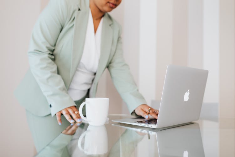 Person In Light Green Suit Using A Laptop