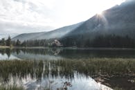 日出时分，宁静的湖景与房屋、山峦和森林共同营造出安详的氛围