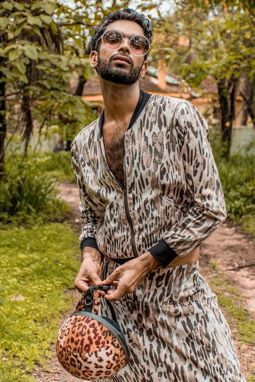 Free Fashionable ethnic man with purse in nature Stock Photo