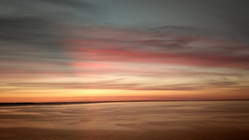 Body of Water Under Cloudy Sky during Sunset