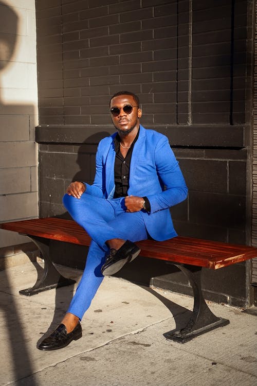 Free Man in Blue Business Suit Sitting on Brown Wooden Bench Stock Photo