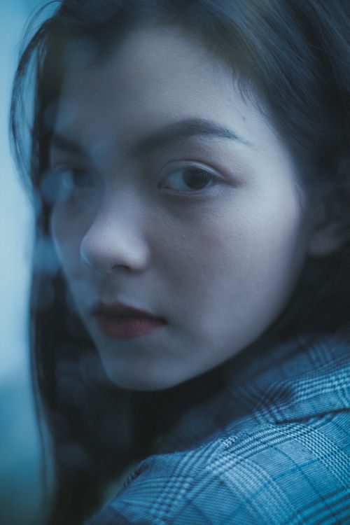 Free Through glass of pensive teenager with red lips thoughtfully looking over shoulder at camera Stock Photo