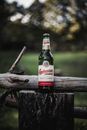 Red and White Labeled Bottle on Brown Wood