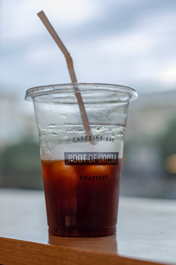 Plastic Cup With Iced Tea On Wooden Table