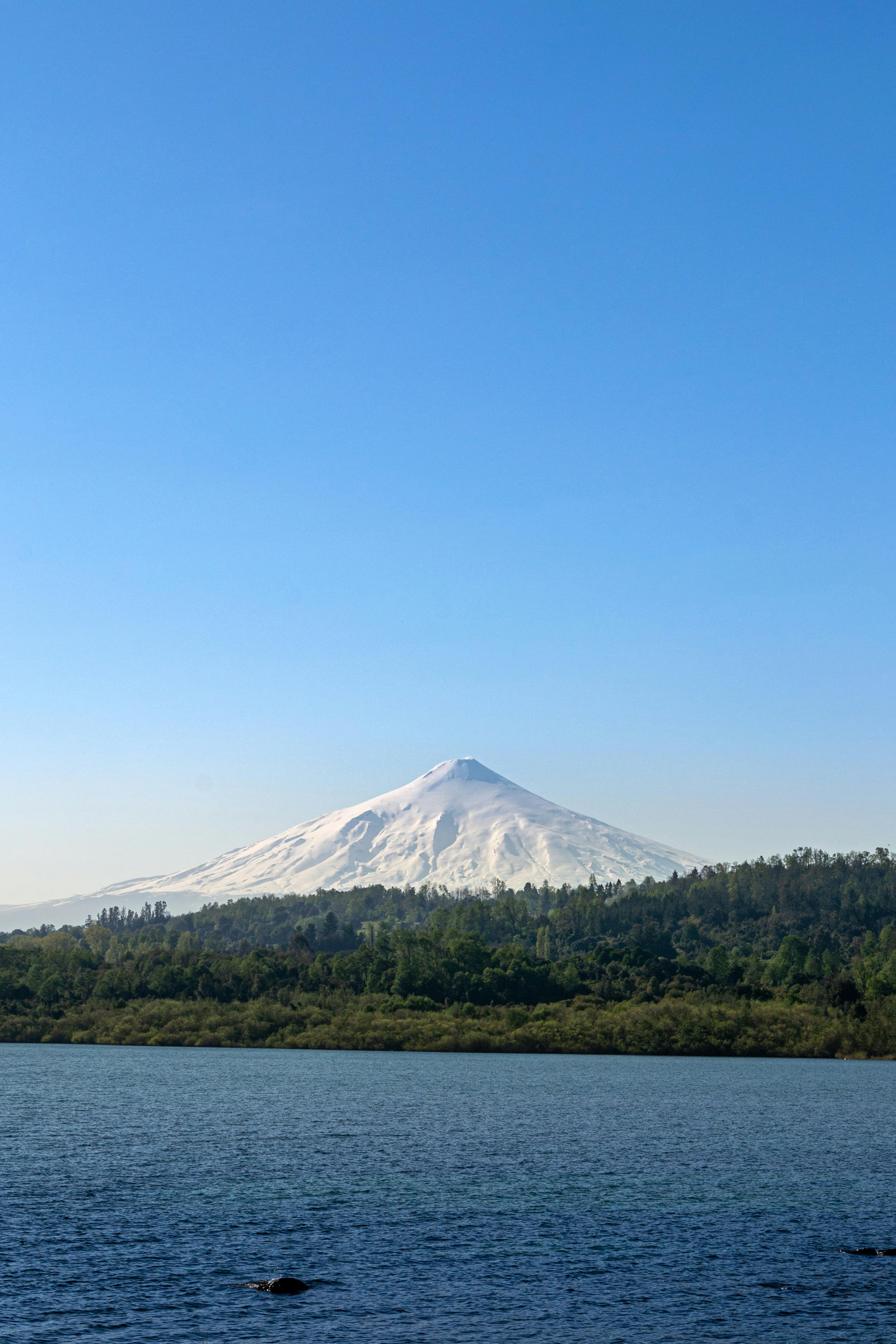 Volcán Villarrica with snow-covered peak reflected in Lake Villarrica, La Araucanía, Chile