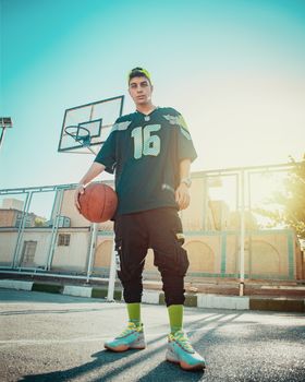 Dynamic portrait of a young basketball player on an outdoor court in Iran.
