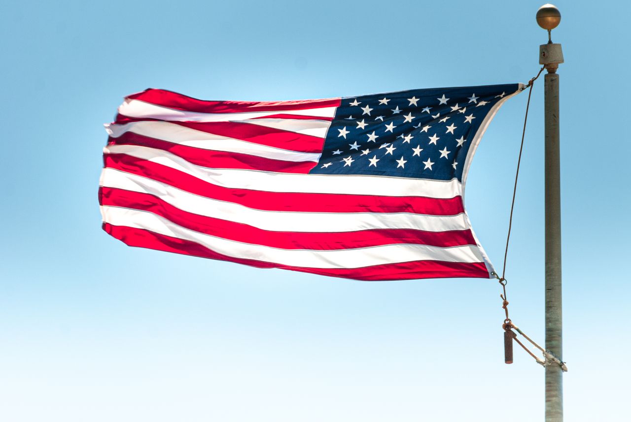 iconic image of the american flag waving in a clear blue sky symbolizi