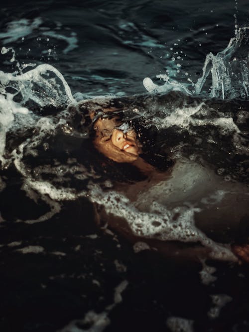 Anonymous woman lying under water