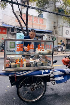 A man selling traditional street food from a mobile cart in Chengdu, China.