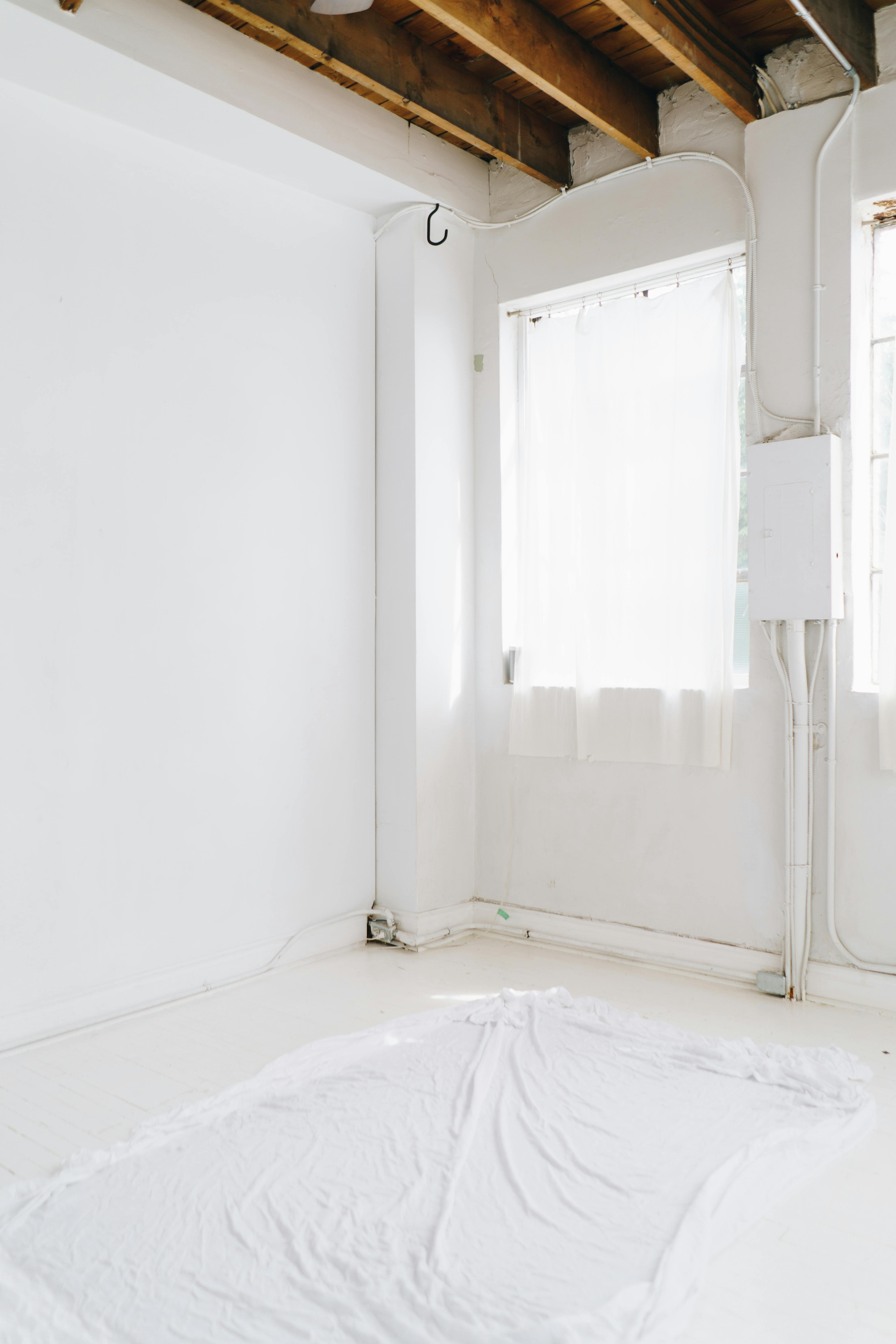 A sunlit empty room with white walls, perfect for a renovation project.