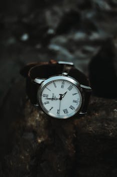 Close-up of a classic wristwatch on a rugged stone background highlighting elegance and time concept.