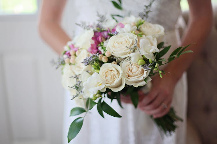 Brides Holding White Bouquet Of Roses