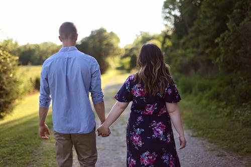 Free Couple Holding Hands While Walking on Path Stock Photo