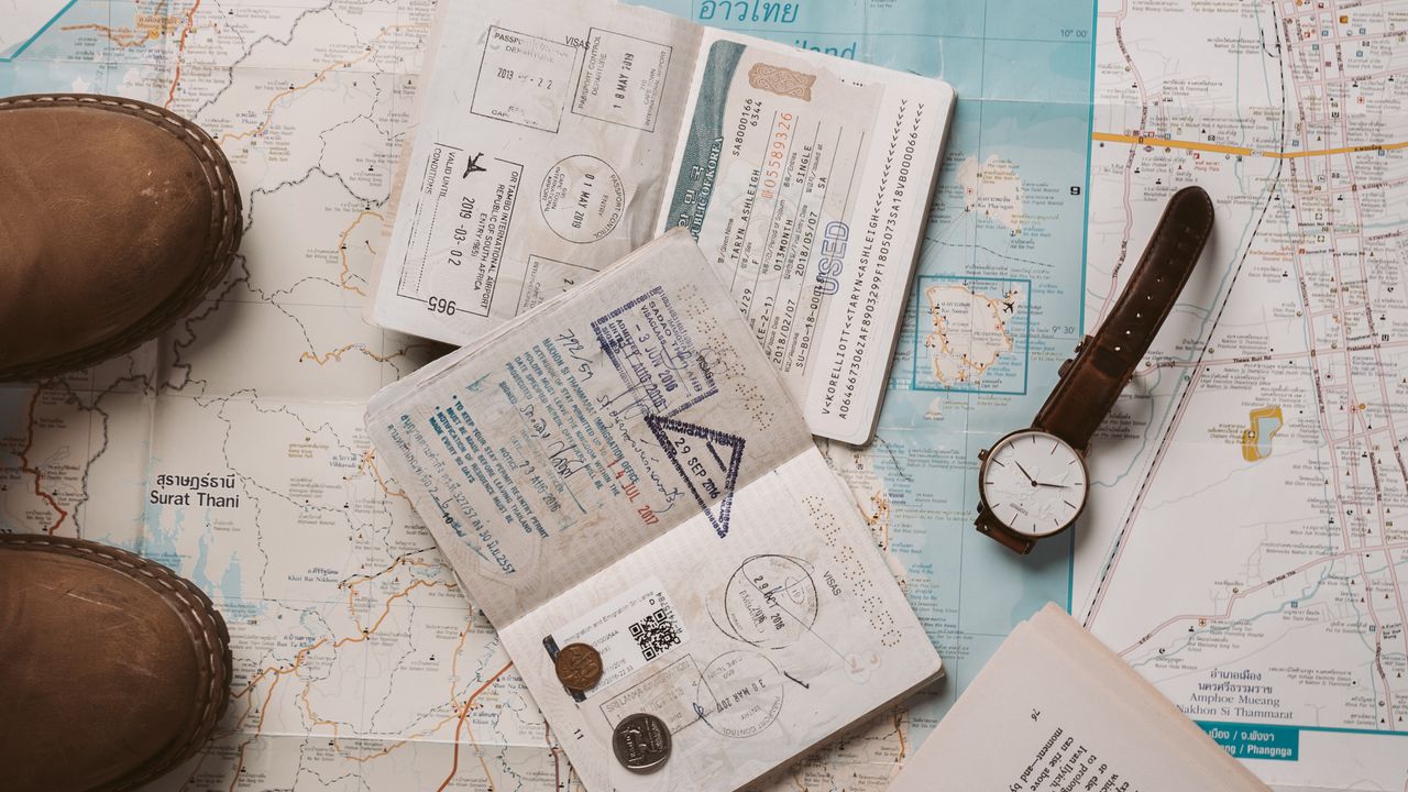 Carte de voyage, photos et appareil photo posés sur une table.