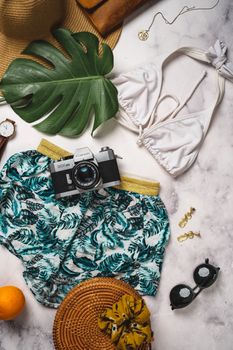 A curated flat lay of summer vacation essentials including swimwear, camera, and tropical accessories.. pexels, curated, flat