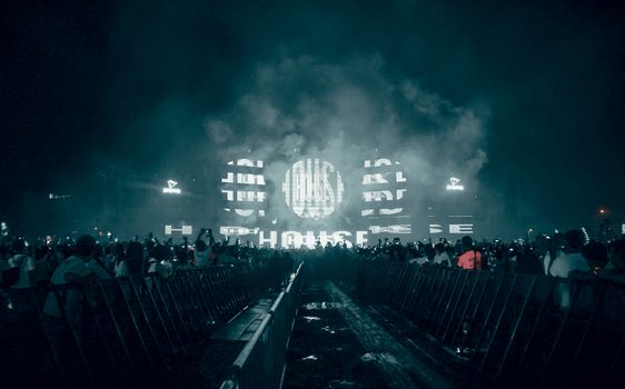 Energetic crowd enjoying a live music performance with stunning light effects in Ho Chi Minh City.
