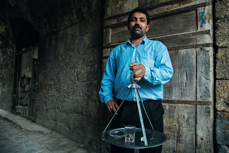 Stylish Bearded Ethnic Man With Tray In Old House