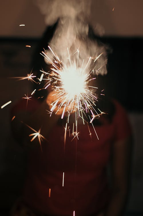 Free Woman showing bright scintillating sparkler Stock Photo